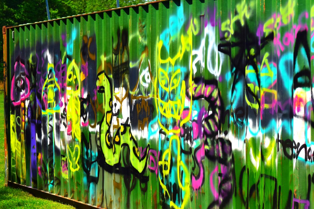 colorful layers of graffiti on the side of a cargo shipping box